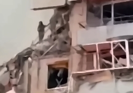 A woman is seen at the edge of her destroyed apartment