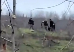 UA troops recover a wounded comrade; an explosion goes off nearby