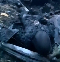  Ukrainian soldier shows a burned body of a Russian soldier 