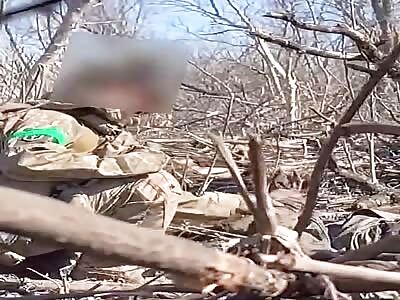 UA soldier plays with the hand of a Russian corpse