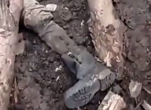 UA soldiers move through a trench that has RF bodies in it