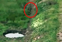 A munition explodes in front of a walking Russian soldier