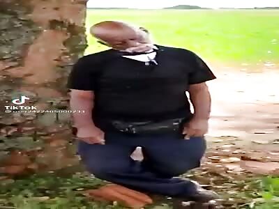 Bald man hanged from a tree.