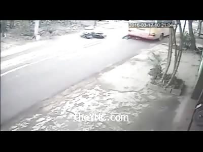 Biker Slides Under Bus Wheel