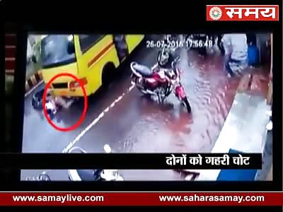 TWO ON A SCOOTER BEING DRAGGED UNDER A BUS