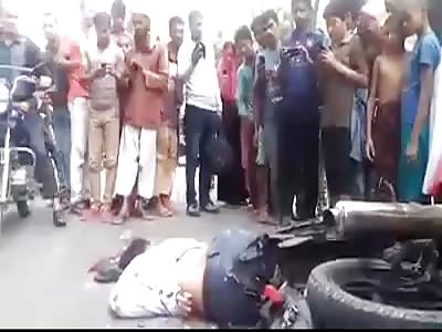 MOTORCYCLIST WITH SPREADED BRAIN ON ASPHALT