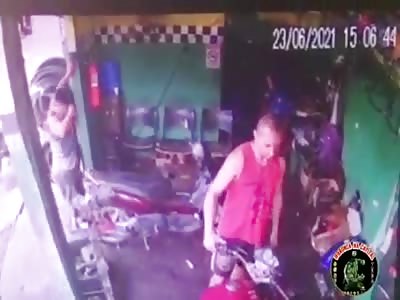 MAN BEING EXECUTED IN A MOTORCYCLE WORKSHOP