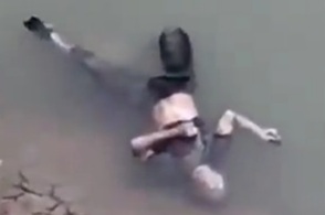 Two guys are fishing, and a dead man lies next to them. 