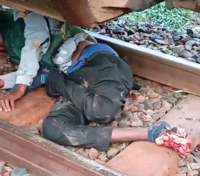 A guy walks between a railway line and gets knocked down by a train.