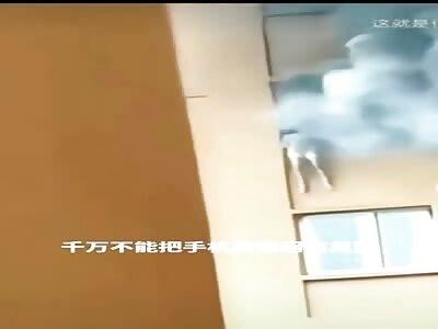 Woman trapped in the window of burning building can't resist anymore 