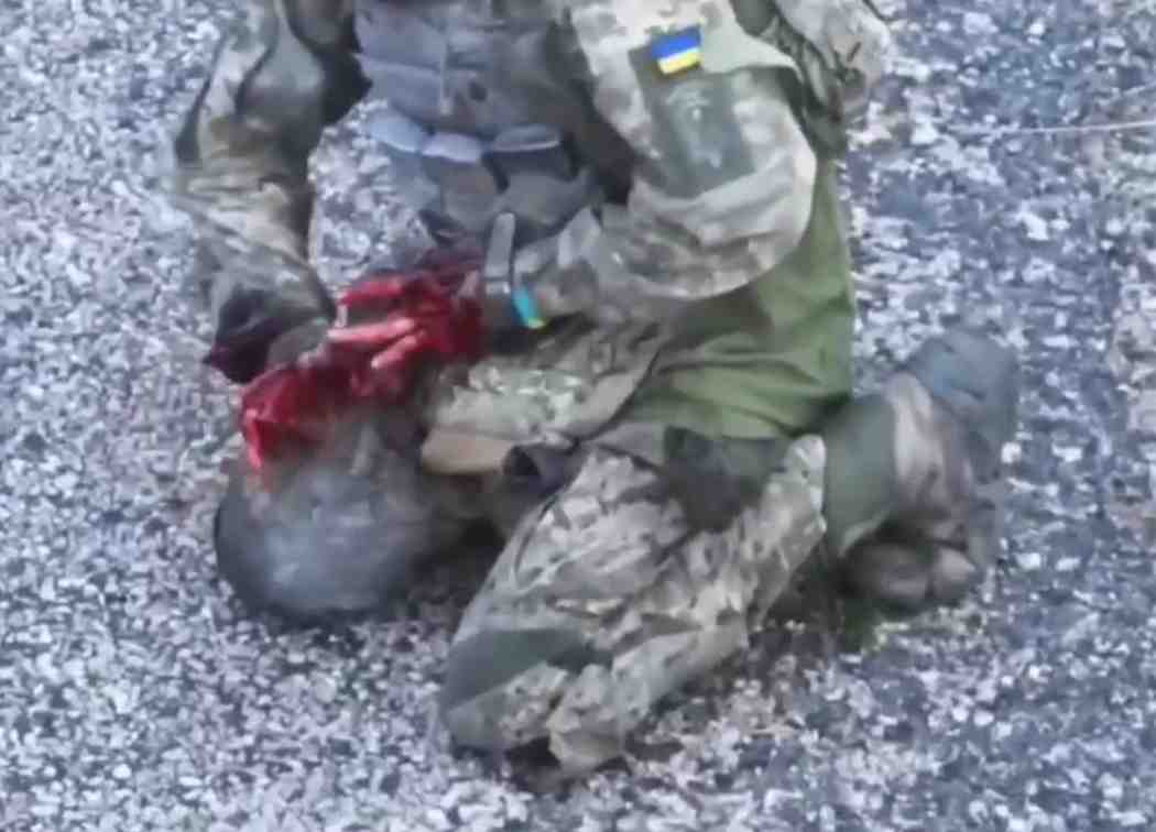 Ukrat, with his hands destroyed, tries to use a tourniquet.