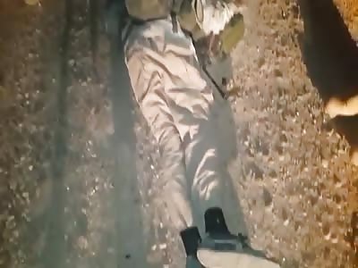 Iraqi soldiers show their fallen opponents